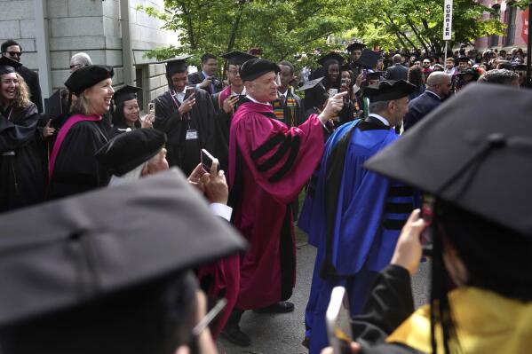 Actor Tom Hanks, center, greets people as he walks in a procession though Harvard Yard at the start of Harvard University commencement exercises, Thursday, May 25, 2023, on the school's campus, in Cambridge, Mass. (AP Photo/Steven Senne)