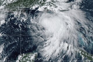 This satellite photo provided by the National Oceanic and Atmospheric Administration shows Tropical Storm Sally, Sunday, Sept. 13, 2020, at 2050 GMT. Sally churned northward on Sunday, poised to turn into a hurricane and send a life-threatening storm surge along the northern Gulf of Mexico. (NOAA via AP)