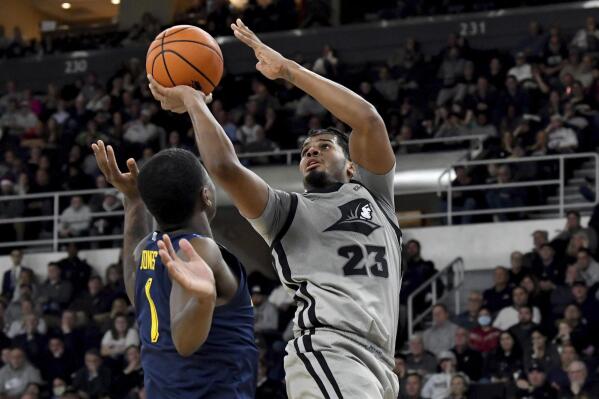 Providence's Bryce Hopkins (23) puts up the ball for a pair of points as Marquette's Kam Jones defends during overtime of an NCAA college basketball game, Tuesday, Dec. 20, 2022, in Providence, R.I. (AP Photo/Mark Stockwell)