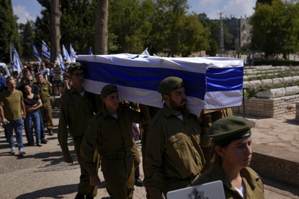 Israeli soldiers carry the flag-covered coffin of Maya Villalobo during her funeral at the military cemetery in Givatayim, Israel, Friday, Oct. 13, 2023. Villalobo was killed when Hamas militants went on a brutal rampage through southern Israel last Saturday, part of an unprecedented, multi-front attack on the country. (AP Photo/Francisco Seco)