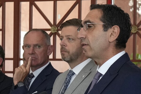 Cyprus' interior minister Konstantinos Ioannou, right, talks to the media during a press conference as his counterparts Austria's Gerhard Karner, left, and Czech's Vít Rakusan stand by during the Ministerial Summit Migration and Syria Dynamics in capital Nicosia, Cyprus, Friday, May 17, 2024. The governments of eight European Union member states say the situation inside Syria should be re-evaluated to allow for voluntary returns of Syrian refugees back to their homeland. (AP Photo/Petros Karadjias)