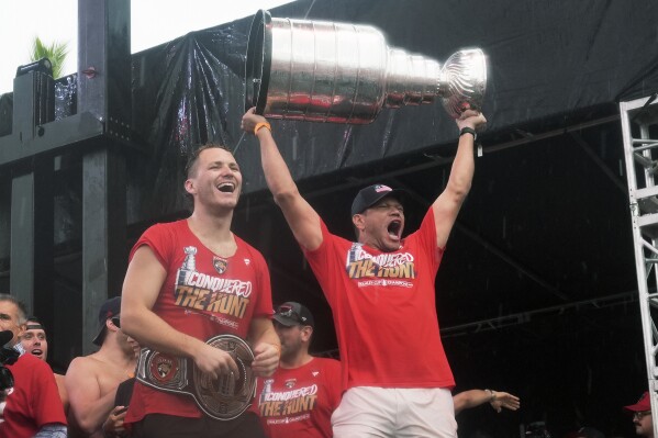 Florida Panthers' Matthew Tkachuk, left, and Kyle Okposo, right, celebrate with the Stanley Cup during an NHL hockey parade and rally, Sunday, June 30, 2024, in Fort Lauderdale, Fla. The Panthers defeated the Edmonton Oilers to win the championship series. (ĢӰԺ Photo/Marta Lavandier)