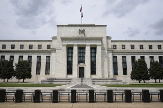 FILE - An American flag flies over the Federal Reserve building on May 4, 2021, in Washington. The Federal Reserve has launched their instant payment service, FedNow, which allows banks and credit unions to sign up to send real-time payments between them. (AP Photo/Patrick Semansky, File)