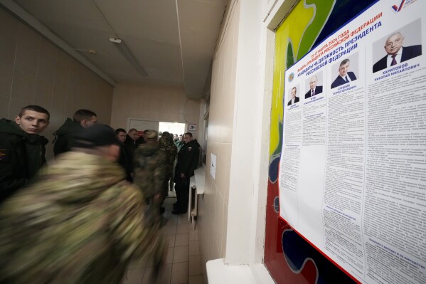 Russian servicemen stand in line to vote at a polling station during a presidential election in St. Petersburg, Russia, Friday, March 15, 2024. Voters in Russia headed to the polls for a presidential election that was all but certain to extend President Vladimir Putin's rule after he clamped down on dissent. (AP Photo/Dmitri Lovetsky)