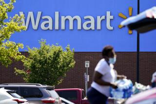 A shopper loads items into her car in the parking lot of a Walmart in Willow Grove, Pa., Wednesday, May 19, 2021. Walmart says it will start commercializing its delivery service, using contract workers, autonomous vehicles and even drones to deliver other retailers' products directly to their customers' homes as fast as just a few hours. (AP Photo/Matt Rourke)