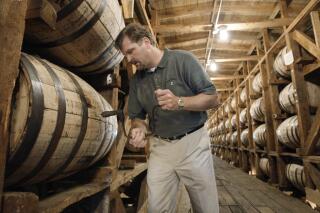 FILE – In this May 20, 2009, file photo, Jeff Arnett, the master distiller at the Jack Daniel Distillery in Lynchburg, Tenn., drills a hole in a barrel of whiskey in one of the aging houses at the distillery. The former top distiller at Jack Daniel's announced on Tuesday, April 20, 2021, that he and several partners are setting up shop for a new whiskey distillery near the Great Smoky Mountains in Tennessee. (AP Photo/Mark Humphrey, File)