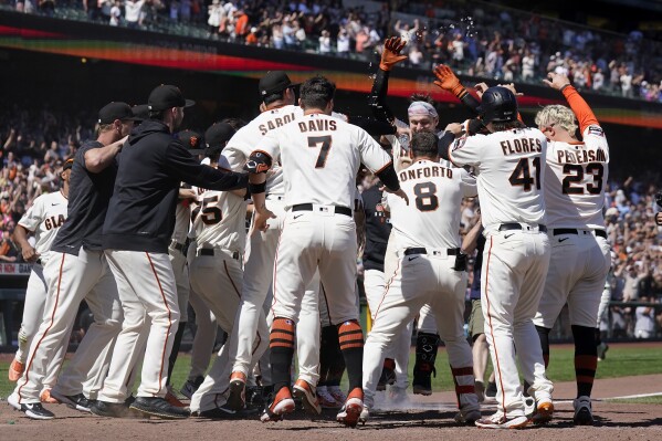 San Francisco Giants' Patrick Bailey, middle right facing, is congratulated by teammates after hitting a two-run home run against the Texas Rangers during the tenth inning of a baseball game in San Francisco, Sunday, Aug. 13, 2023. (AP Photo/Jeff Chiu)
