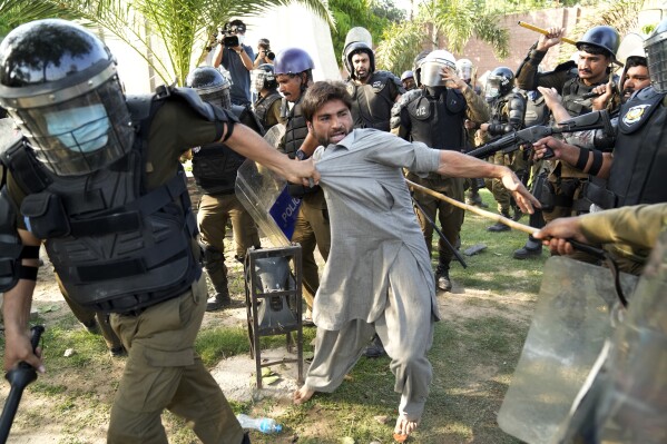 Police detain a supporter of Pakistan's former Prime Minister Imran Khan in Lahore, Pakistan, Wednesday, May 10, 2023. (AP Photo/K.M. Chaudary)