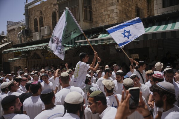 Israelis wave national flags during a march marking Jerusalem Day, an Israeli holiday celebrating the capture of east Jerusalem in the 1967 Mideast war, in Jerusalem's Old City, Monday, May 26, 2025. (AP Photo/Ohad Zwigenberg)