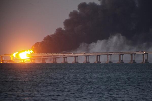 Flame and smoke rise fron Crimean Bridge connecting Russian mainland and Crimean peninsula over the Kerch Strait, in Kerch, Crimea, Saturday, Oct. 8, 2022. Russian authorities say a truck bomb has caused a fire and the partial collapse of a bridge linking Russia-annexed Crimea with Russia. Three people have been killed. The bridge is a key supply artery for Moscow's faltering war effort in southern Ukraine. (AP Photo)
