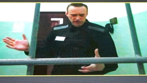 FILE - Russian opposition leader Alexei Navalny is seen on a TV screen as he appears in a video link provided by the Russian Federal Penitentiary Service from the colony in Melekhovo, Vladimir region, during a hearing at the Russian Supreme Court in Moscow, Russia, June 22, 2023. The prosecution has asked the court to sentence imprisoned opposition leader Alexei Navalny to 20 years in prison on extremism charges, his ally Ivan Zhdanov said Thursday July 20, 2023. According to Zhdanov, the trial against Navalny, which went on behind closed doors in the prison where the politician is serving another lengthy sentence, is scheduled to conclude with a verdict on Aug. 4. (AP Photo/Alexander Zemlianichenko, File)