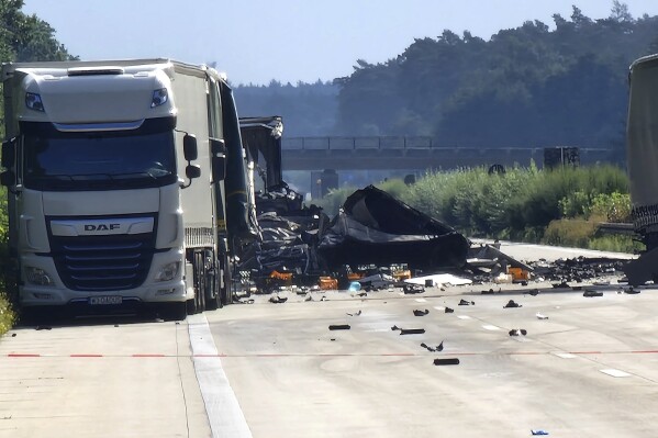Debris from a truck lies on the highway 2 between Theessen and Burg, Germany, Wednesday, Aug. 30, 2023. At least two people have died and one person has been injured in an accident on a German highway, when a truck transporting the hazardous goods crashed into three other trucks and then a fifth truck loaded with high-pressure containers filled with nitrous oxide crashed into the four other trucks. German news agency dpa reported that the accident happened Tuesday near a construction site on the A2 highway near the city of Magdeburg. (Cevin Dettlaff/dpa via AP)