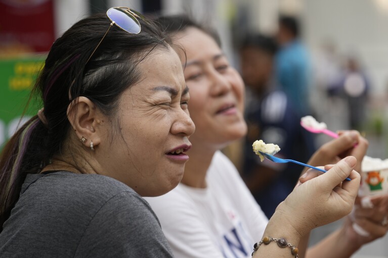 Women enjoy ice cream in Bangkok, Thailand, Tuesday, April 9, 2024. Thailand, Cambodia and other countries in this region are celebrating with their annual water festivals as they also suffer through the global heat wave. (AP Photo/Sakchai Lalit)