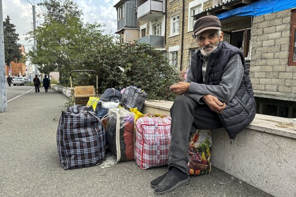 An ethnic Armenian man sits near his flat in an apartment building, in hope to leave Nagorno-Karabakh region for Armenia in the center of Stepanakert, Nagorno-Karabakh on Monday, Sept. 25, 2023. The separatist government of Nagorno-Karabakh announced Thursday that it will dissolve itself and the unrecognized republic will cease to exist by the end of the year, and Armenian officials said more than half of the population has already fled. (AP Photo/Ani Abaghyan)