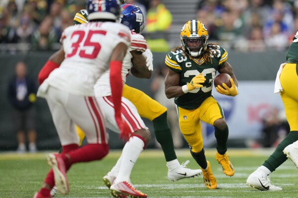 FILE - Green Bay Packers running back Aaron Jones (33) carries the ball during the second half of an NFL football game against the New York Giants at the Tottenham Hotspur stadium in London, on Oct. 9, 2022. The NFL will continue staging at least two games per year at Tottenham Hotspur Stadium through the 2029 season, it announced Thursday, Sept. 14, 2023. (AP Photo/Kin Cheung, File)
