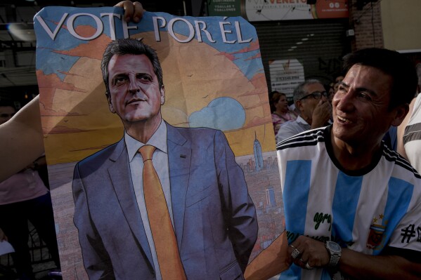 A supporter of Economy Minister Sergio Massa, the ruling party鈥檚 presidential candidate, holds a campaign poster promoting Massa, in Ezeiza, Buenos Aires province, Argentina, Wednesday, Nov. 15, 2023. As Argentina heads for a presidential Nov. 19 runoff election, the decades-old populist movement known as Peronism has Massa working overtime to keep once-steadfast supporters from straying to his opponent, right-wing populist Javier Milei. (AP Photo/Natacha Pisarenko)