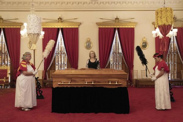 Veronica Gail Kawananakoa, center, wife of Abigail Kinoiki Kekaulike Kawananakoa, stands by her wife's casket during a public memorial at 'Iolani Palace, Sunday, Jan. 22, 2023, in Honolulu. The Campbell estate heiress with royal lineage died on Dec. 11, 2022, at the age of 96. Also pictured are members of the Hawaiian Royal Society Hale O Na Ali'i, which Kawananakoa was a member of. (Cindy Ellen Russell/Honolulu Star-Advertiser via AP)