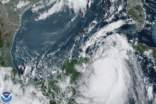 In this Monday, Aug. 28, 2023, 9:41 am ET satellite image provided by the National Oceanic and Atmospheric Administration, Tropical Storm Idalia moves between Mexico's Yucatan peninsula, left, and Cuba, right. Idalia intensified early Monday and was expected to become a major hurricane before it reaches Florida's Gulf coast, according to the National Hurricane Center. (NOAA via AP)