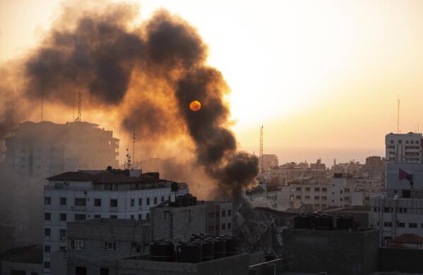 Smoke is seen from a collapsed building after it was hit by Israeli airstrikes on Gaza City, Wednesday, May 12, 2021. The Israeli airstrike was the latest in a series of assaults on targets in the Gaza Strip after a long dispute between Israel and Hamas erupted into an exchange of rocket attacks from Gaza and Israeli retaliation. (AP Photo/Khalil Hamra)