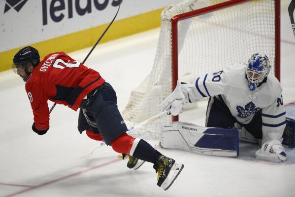 Washington Capitals left wing Alex Ovechkin (8) is tripped by Toronto Maple Leafs goaltender Erik Kallgren (50) during the third period of an NHL hockey game, Sunday, April 24, 2022, in Washington. Ovechkin left with an injury after the play. (AP Photo/Nick Wass)