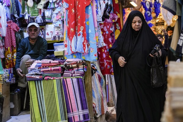 An Iraqi woman shops for clothes ahead of Eid al-Fitr at the Shorjah market in central Baghdad, Iraq, Thursday, March 27, 2025. Eid al-Fitr marks the end of the holy fasting month of Ramadan. (AP Photo/Hadi Mizban)