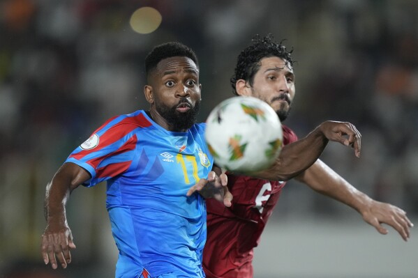 DR Congo's Cedric Bakambu, left and Egypt's Ahmed Hegazi challenge for the ball during the African Cup of Nations Round of 16 soccer match between Egypt and DR Congo, at the Laurent Pokou stadium in San Pedro, Ivory Coast, Sunday, Jan. 28, 2024. 2024. (AP Photo/Sunday Alamba)