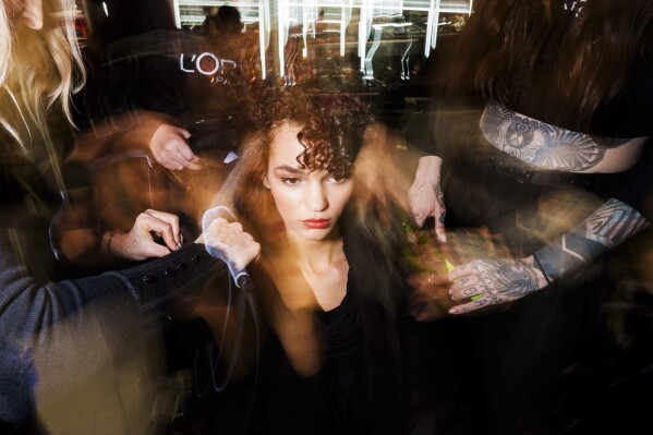 Makeup artists work backstage prior a fashion show at the Mercedes-Benz Fashion Week in Madrid, Friday, Feb. 21, 2025. (AP Photo/Bernat Armangue)