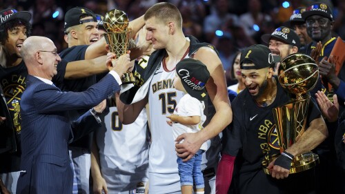 Commissioner Adam Silver, left, hands the MVP award to Denver Nuggets center Nikola Jokic, center, after the team won the NBA Championship with a victory over the Miami Heat in Game 5 of basketball's NBA Finals, Monday, June 12, 2023, in Denver. (AP Photo/Jack Dempsey)