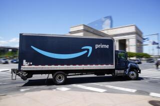 FILE - An Amazon truck drives in in Philadelphia, Friday, April 30, 2021. Amazon wants to hire 125,000 delivery and warehouse workers and said Tuesday, Sept. 14, 2021 that it is paying new hires an average of $18 an hour in a tight job market as more people shop online. The company is also offering pay sign-on bonuses of $3,000 in some parts of the country. (AP Photo/Matt Rourke, file)