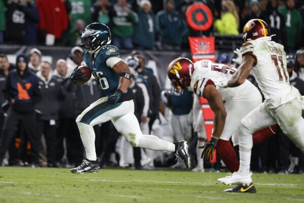 Philadelphia Eagles running back Saquon Barkley, left, runs for a touchdown during the second half of an NFL football game against the Washington Commanders Thursday, Nov. 14, 2024, in Philadelphia. (AP Photo/Laurence Kesterson, File)