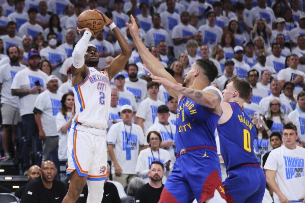 Oklahoma City Thunder's Shai Gilgeous-Alexander (2) shoots over Denver Nuggets' Michael Porter Jr. (1) and Christian Braun (0) in the second half of Game 5 of an NBA basketball second-round playoff series Tuesday, May 13, 2025, in Oklahoma City. (AP Photo/Nate Billings)