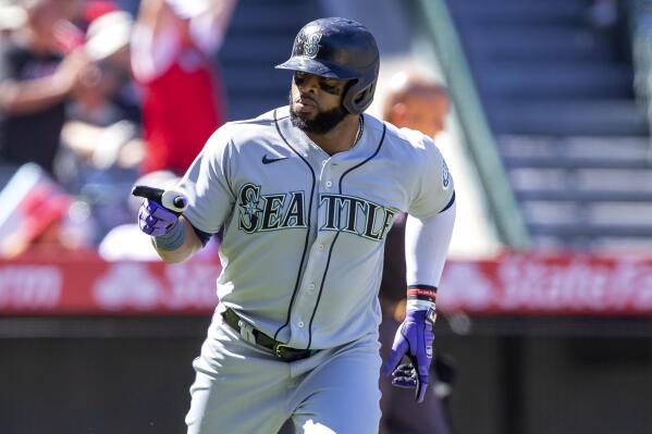 Seattle Mariners' Ty France holds his bat on his helmet after