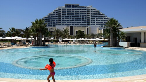 A child enjoys the pool at the City of Dreams Mediterranean in southern coastal city of Limassol, Cyprus, on Tuesday, July 11, 2023. Officials say a new casino resort touted as the largest of its kind in Europe has opened its doors in Cyprus, aiming to transform the east Mediterranean island nation as a year-round destination for luxury tourism. (AP Photo/Petros Karadjias)