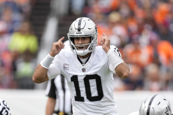 Las Vegas Raiders quarterback Jimmy Garoppolo (10) gives signals at the line during the first half of an NFL football game against the Denver Broncos, Sunday, Sept. 10, 2023, in Denver. (AP Photo/David Zalubowski)