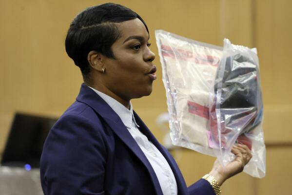 During her closing arguments in the XXXTentacion murder trial, Assistant State Attorney Pascale Achille holds up a camouflage hat with a red brim that was seen worn by shooting suspect Michael Boatwright in multiple surveillance videos included as evidence in the case, at the Broward County Courthouse in Fort Lauderdale, Fla., Tuesday, March 7, 2023. Emerging rapper XXXTentacion, born Jahseh Onfroy, 20, was killed during a robbery outside of Riva Motorsports in Pompano Beach in 2018, allegedly by defendants Michael Boatwright, Trayvon Newsome, and Dedrick Williams. (Amy Beth Bennett/South Florida Sun-Sentinel via AP, Pool)