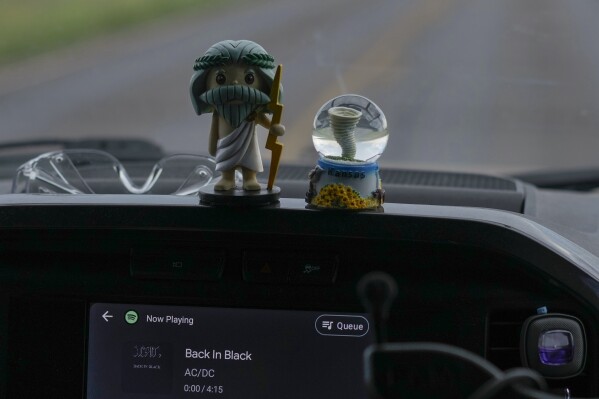 Dashboard mascots Zeus, left, and Tor, right, sit in a car as AC/DC's “Back in Black” plays on the stereo in Northern Illinois University's Husky Hail Hunter vehicle, as they drive into a storm during a Project ICECHIP operation, Friday, June 6, 2025, near Levelland, Texas. (AP Photo/Carolyn Kaster)