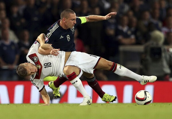FILE - Germany's Toni Kroos, bottom, vies for the ball with Scotland's captain Scott Brown during their Euro 2016 Group D qualifying soccer match at Hampden Park, Glasgow, Scotland, Monday Sept. 7, 2015. Host nation Germany may be the heavyweight in its European Championship group, but any of Scotland, Hungary or Switzerland is capable of causing an upset in Group A.(AP Photo/Scott Heppell, File)