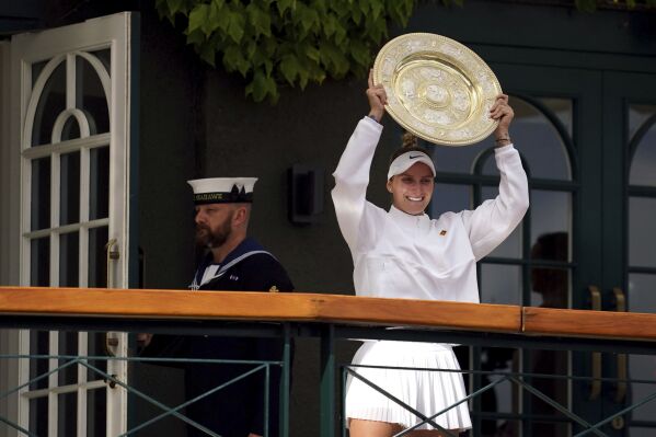 Czech Republic's Marketa Vondrousova celebrates as she shows the trophy from the balcony of Centre Court after beating Tunisia's Ons Jabeur to win the final of the women’s singles on day thirteen of the Wimbledon tennis championships in London, Saturday, July 15, 2023. (Victoria Jones/PA via AP)