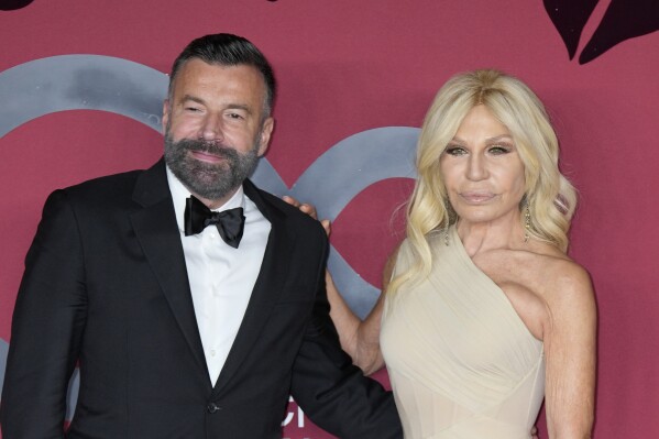 Donatella Versace, right, poses for photographers with Alessandro Zan as they arrive for the CNMI sustainable fashion 2023 awards in Milan, Italy, Sunday, Sept. 24, 2023. Donatella Versace slammed the Italian government for anti-gay policies in a heart-felt speech that referenced her late brother, Gianni Versace, while receiving a fashion award this weekend. (AP Photo/Antonio Calanni)