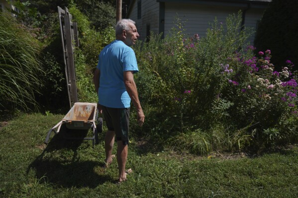 Mike Dulak walks through the large garden surrounding his home in Rocheport, Mo., Friday, Sept. 8, 2023. (AP Photo/Jessie Wardarski)