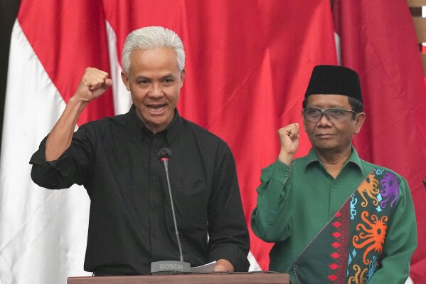 Presidential candidate of the ruling Indonesian Democratic Party of Struggle (PDIP) Ganjar Pranowo, left, and his newly-named running mate Indonesia's Coordinating Minister for Political Legal and Security Affairs Mahfud MD gesture during their declaration as presidential and vice-presidential candidates in Jakarta, Indonesia Wednesday, Oct. 18, 2023. Indonesia is set to hold its presidential election in February next year. (AP Photo/Tatan Syuflana)