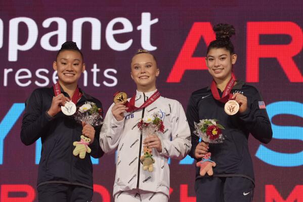 Angelina Melnikova, center, of Russia, with her gold medal, Leanne Wong, left, of the U.S., with her silver medal, and Kayla DiCello, of the U.S., with her bronze medal, pose for a photo during the victory ceremony after the women's all-around finals in the FIG Artistic Gymnastics World Championships in Kitakyushu, western Japan, Thursday, Oct. 21, 2021. (AP Photo/Hiro Komae)