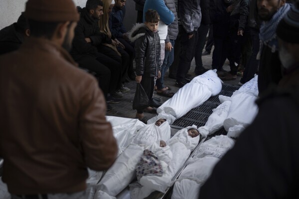 Palestinians mourn their relatives, including kids killed in the Israeli bombardment of the Gaza Strip, outside a morgue in Rafah, southern Gaza, Thursday, Jan. 11, 2024. (AP Photo/Fatima Shbair)