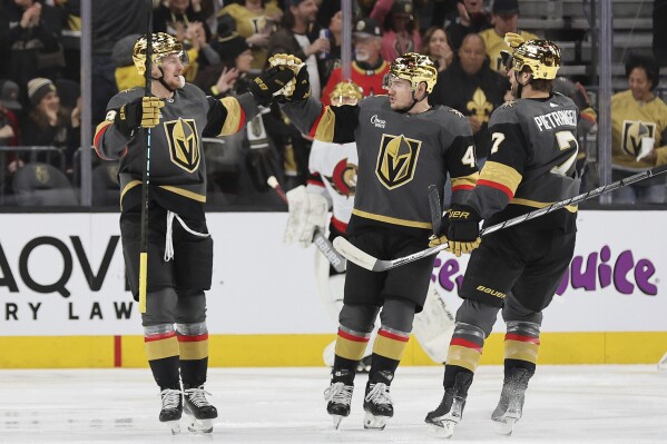 Vegas Golden Knights center Jack Eichel (9) is congratulated by center Ivan Barbashev (49) and defenseman Alex Pietrangelo (7) after Eichel's goal during the first period of an NHL hockey game against the Ottawa Senators, Sunday, Dec. 17, 2023, in Las Vegas. (AP Photo/Steve Marcus)