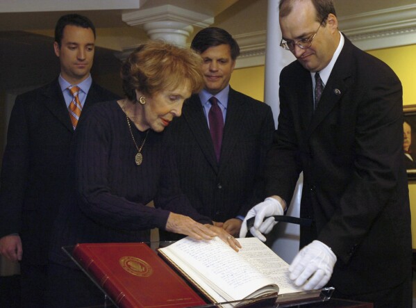 FILE - Nancy Reagan, front left, and supervisory archivist Mike Duggan, front right, place some of former President Ronald Reagan's original diaries on display at the Ronald Reagan Presidential Library May 21, 2007, in Simi Valley, Calif. Presidents from George Washington to Joe Biden have kept presidential diaries. In them, they confide in themselves, express raw opinions, trace even the humdrum habits of their day and offer insight-on-the-fly on monumental decisions of their time. It's where they may also spill secrets they shouldn't. (Eric Parsons/The Ventura County Star via AP)