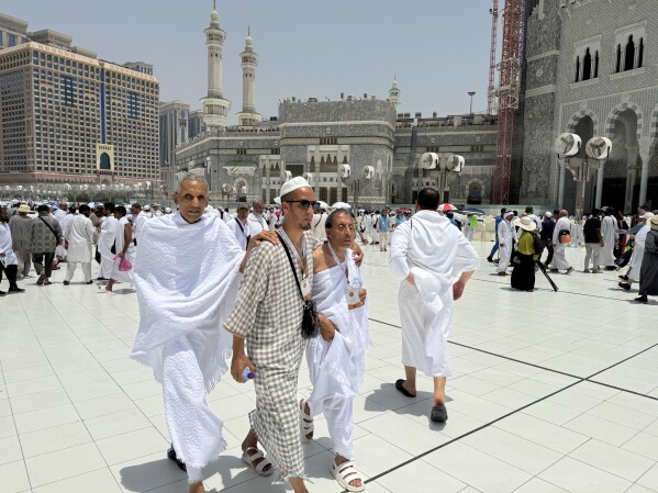 Dos peregrinos ciegos realizan el Hajj con la ayuda de su guía afuera de la Gran Mezquita durante el Hajj anual en La Meca, Arabia Saudita, el jueves 13 de junio de 2024. (Foto AP/Baraa Anwar)