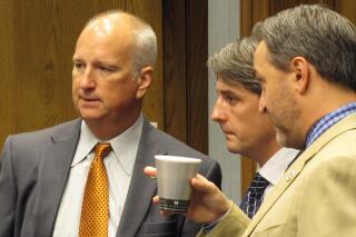 FILE - In this June 20, 2016, file photo, state Rep. Jay Morris, left, R-Monroe; along with Rep. Cameron Henry, R-Metairie; and Sen. Norby Chabert, R-Houma, listen ahead of a House Ways and Means Committee vote in Baton Rouge, La. The Louisiana Senate gave quick final passage Tuesday, June 1, 2021, to a bill that would allow gun owners to carry concealed firearms without a permit, a measure expected to provoke a veto from Gov. John Bel Edwards.  The Senate voted 27-9 Tuesday for House changes to the bill by Republican Sen. Jay Morris of Monroe. (AP Photo/Melinda Deslatte, File(