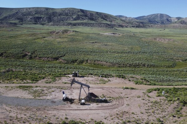 FILE - A pumpjack dips its head to extract oil in a basin north of Helper, Utah, July 13, 2023. The U.S. Forest Service on Wednesday, Jan. 17, 2024, withdrew its approval of a right-of-way permit that would have allowed the construction of a railroad project through about 12 miles (19 kilometers) of roadless, protected forest in northeastern Utah. (AP Photo/Rick Bowmer, File)
