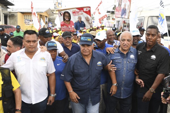 Presidential candidate Jose Raul Mulino, center, campaigns in the San Miguelito neighborhood of Panama City, Wednesday, April 10, 2024. The former foreign minister is one of eight candidates competing in the upcoming May 5th presidential election. (AP Photo/Agustin Herrera)