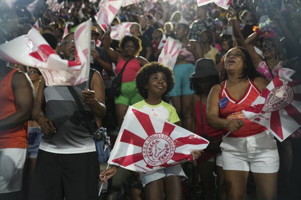 Fans cheer before the Unidos de Padre Miguel samba school parade during Carnival celebrations at the Sambadrome in Rio de Janeiro, Sunday, March 2, 2025. (AP Photo/Silvia Izquierdo)